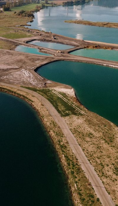 An aerial shot of a landscape surrounded by mountains and lakes with industrial disaster